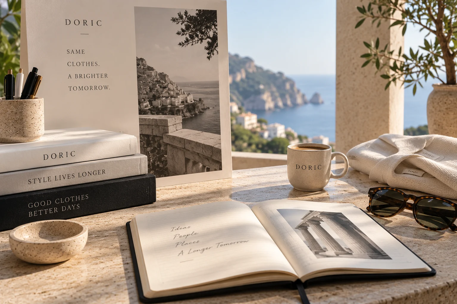 A desk of DORIC volumes and a folded knit above a coastal view